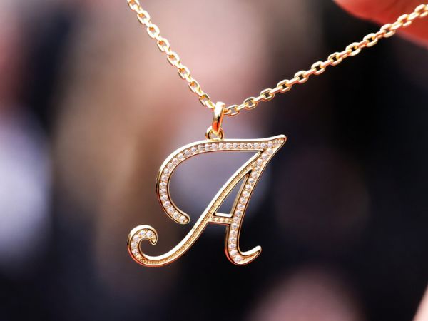 Złoty naszyjnik celebrytka z literką – personalizacja biżuterii krok po kroku